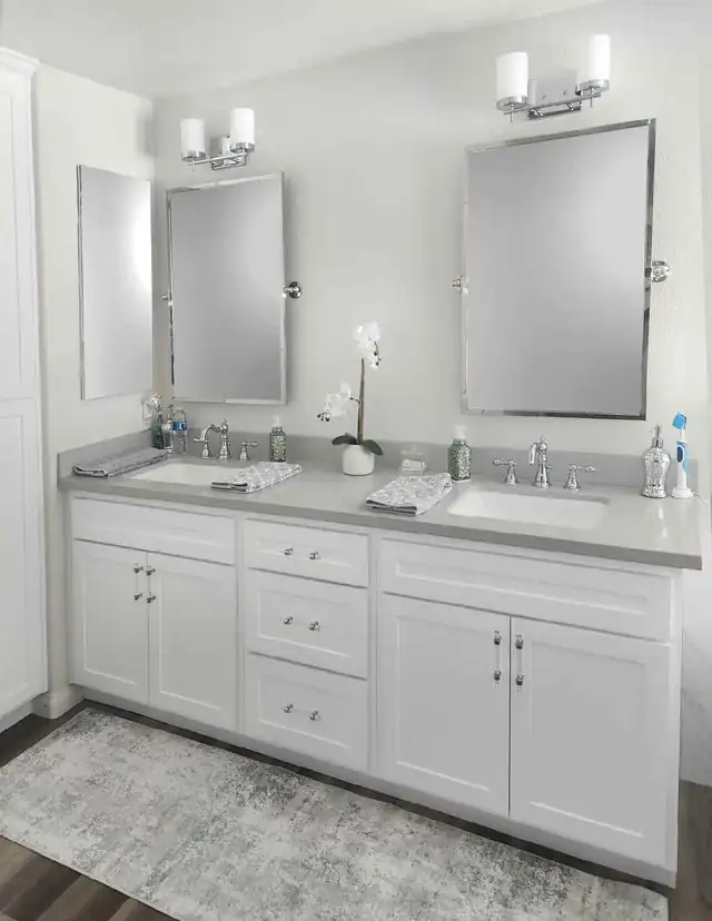 White Shaker double vanity with gray quartz top, polished nickel sconces and pivot mirrors