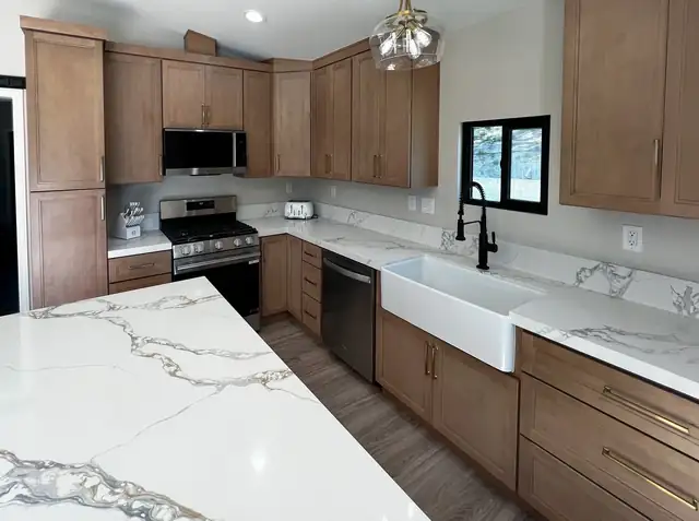 Temecula Wine Country ADU kitchen with golden-toned birch Shaker cabinets, brushed gold pulls, Calacatta De Oro quartz and a farmhouse sink