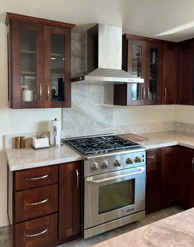 Meadowview Estates kitchen in Temecula with espresso Shaker cabinets, glass-front uppers, stainless range and quartzite backsplash